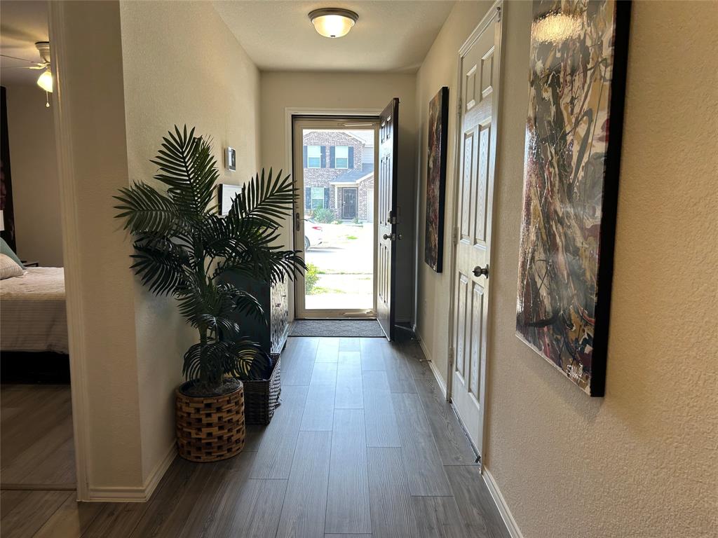 10109 Wyseby Road Crowley, TX 76036 - Photo 2 of 25 a view of a hallway with wooden floor and a potted plant