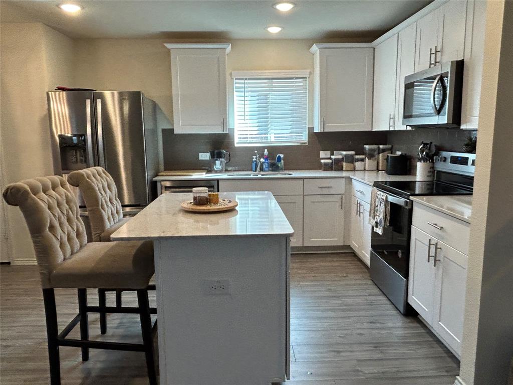 10109 Wyseby Road Crowley, TX 76036 - Photo 9 of 25 a kitchen with stainless steel appliances granite countertop a stove top oven a refrigerator a sink and dishwasher with wooden floor