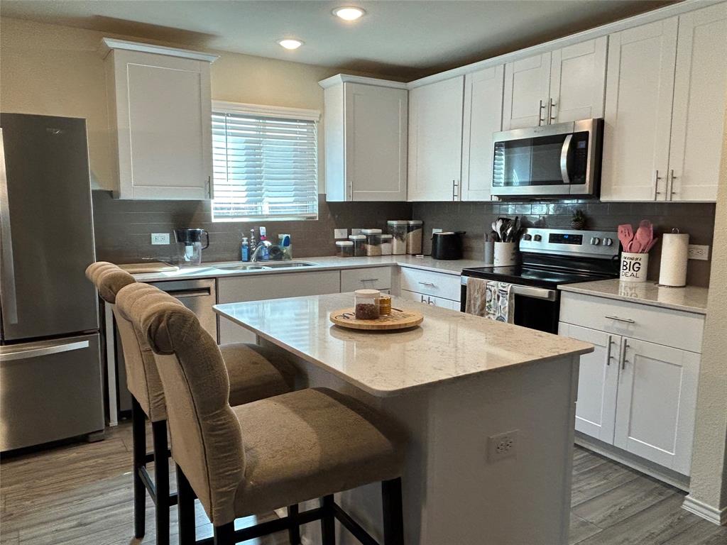 10109 Wyseby Road Crowley, TX 76036 - Photo 10 of 25 a kitchen with a stove a sink a microwave a dining table and chairs