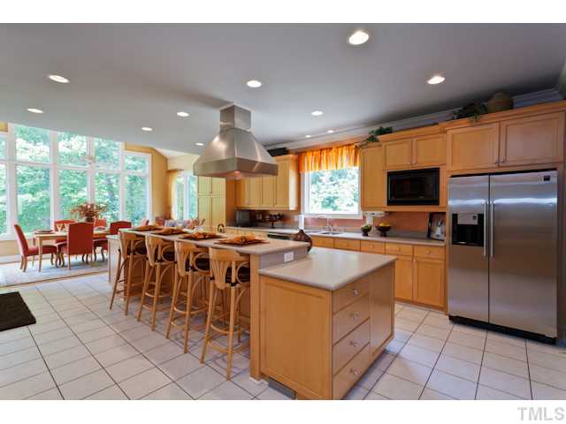 7716 Senter Farm Road Apex, NC 27539 - Photo 2 of 25 The gorgeous, chef's kitchen features solid surface counter tops, stainless steel appliances, recessed lighting, a huge eat-at island, and a built in desk. Refrigerator and microwave are included as well.
