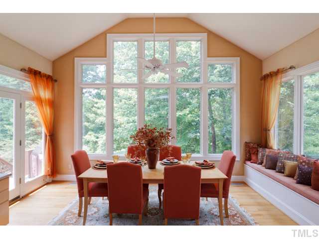 7716 Senter Farm Road Apex, NC 27539 - Photo 3 of 25 Enjoy meals in this stunning breakfast nook. Fabric covered wall add to the charm of this space, as well as the decorative window seat. Enjoy views of the wooded lot with three walls of windows.
