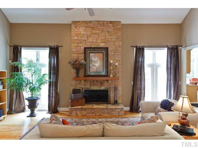 7716 Senter Farm Road Apex, NC 27539 - Photo 4 of 25 This home boasts custom features throughout, such as this hand made stacked stone fireplace. Double French doors on either side lead to one of the four decks outside.