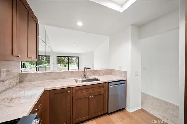 a kitchen with granite countertop cabinets stainless steel appliances and wooden floor