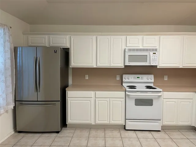 a kitchen with cabinets stainless steel appliances and a counter space