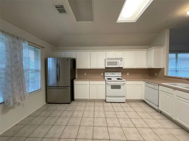 a kitchen with a stove top oven sink and cabinets