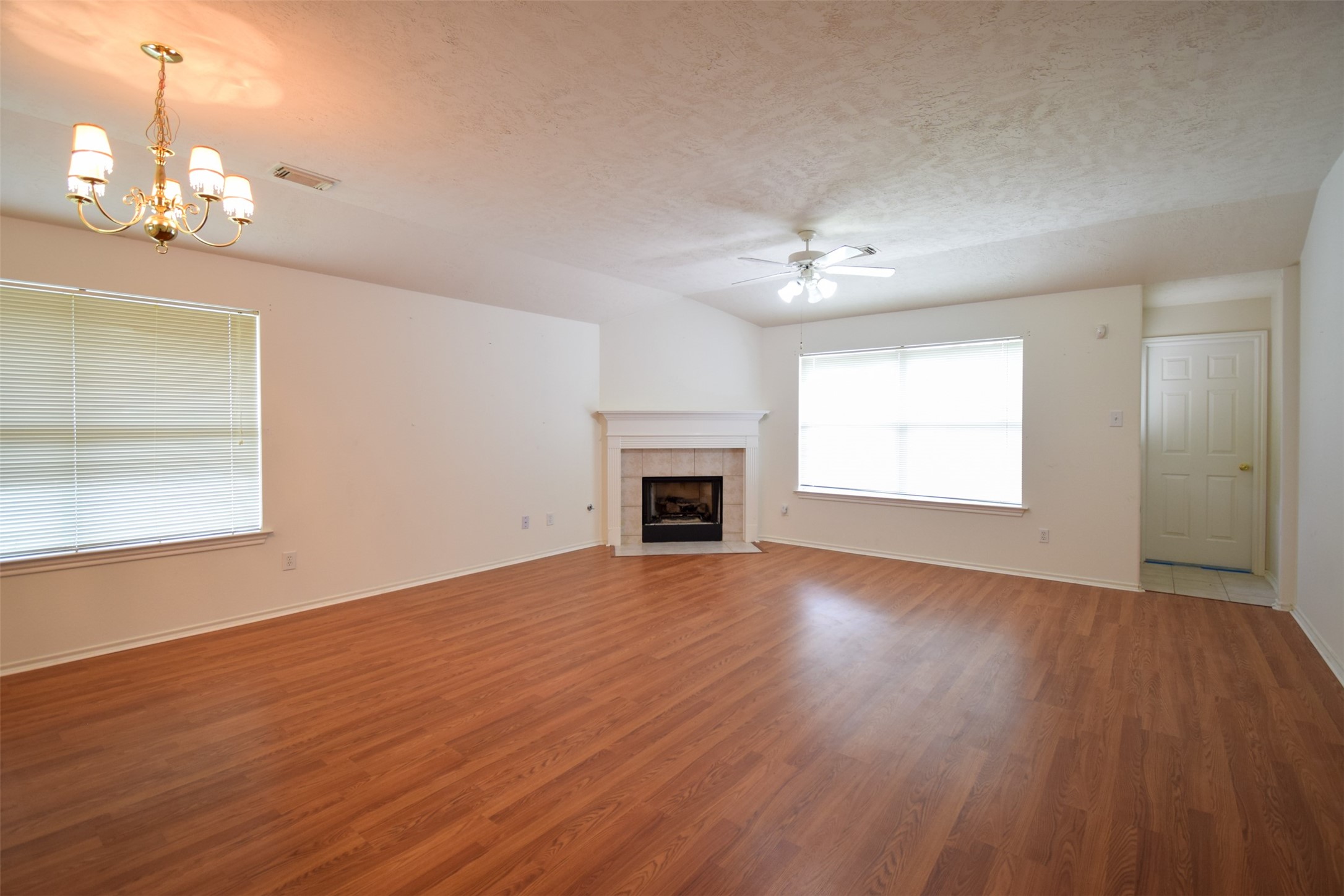 21315 Pepperberry Trail Spring, TX 77388 - Photo 7 of 21 an empty room with wooden floor chandelier and fireplace