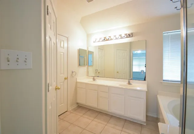 a bathroom with a double vanity sink and mirror