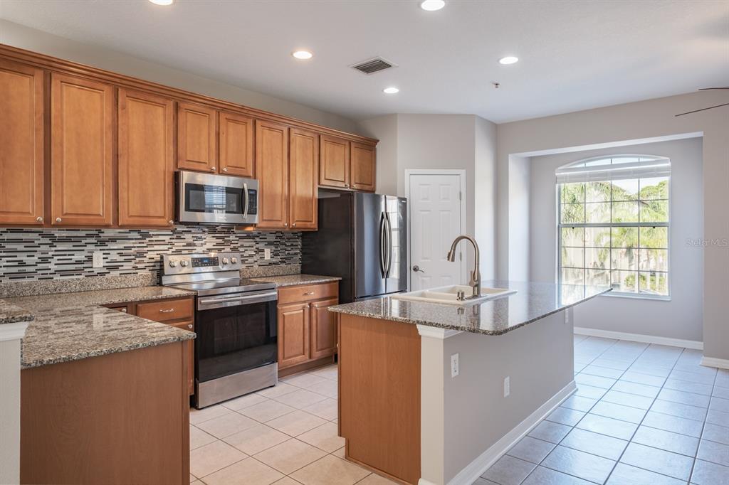 10220 Bayou Grande Seminole, FL 33772 - Photo 19 of 50 a kitchen with stainless steel appliances granite countertop a sink stove and refrigerator