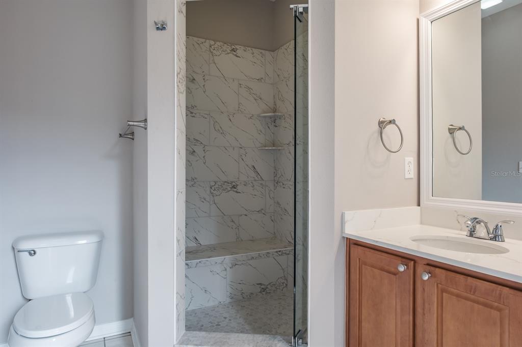10220 Bayou Grande Seminole, FL 33772 - Photo 32 of 50 a bathroom with a granite countertop sink a toilet and shower