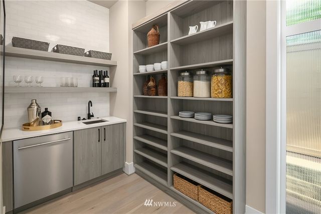 a kitchen with white cabinets and window
