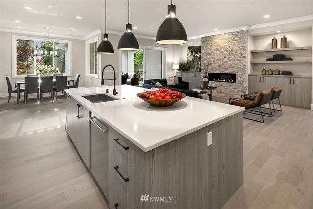 a kitchen with stainless steel appliances a sink a stove and a living room
