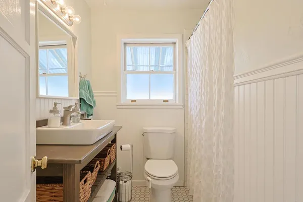 a bathroom with a sink a toilet and a window