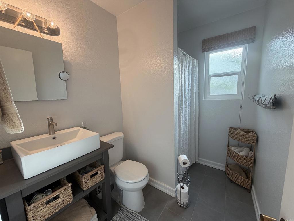 417 5th Street Coronado, CA 92118 - Photo 48 of 48 a bathroom with a toilet a sink and mirror