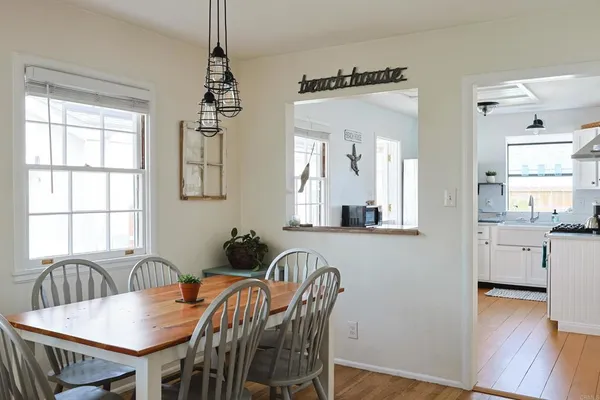 a view of a a dining room with furniture window and wooden floor