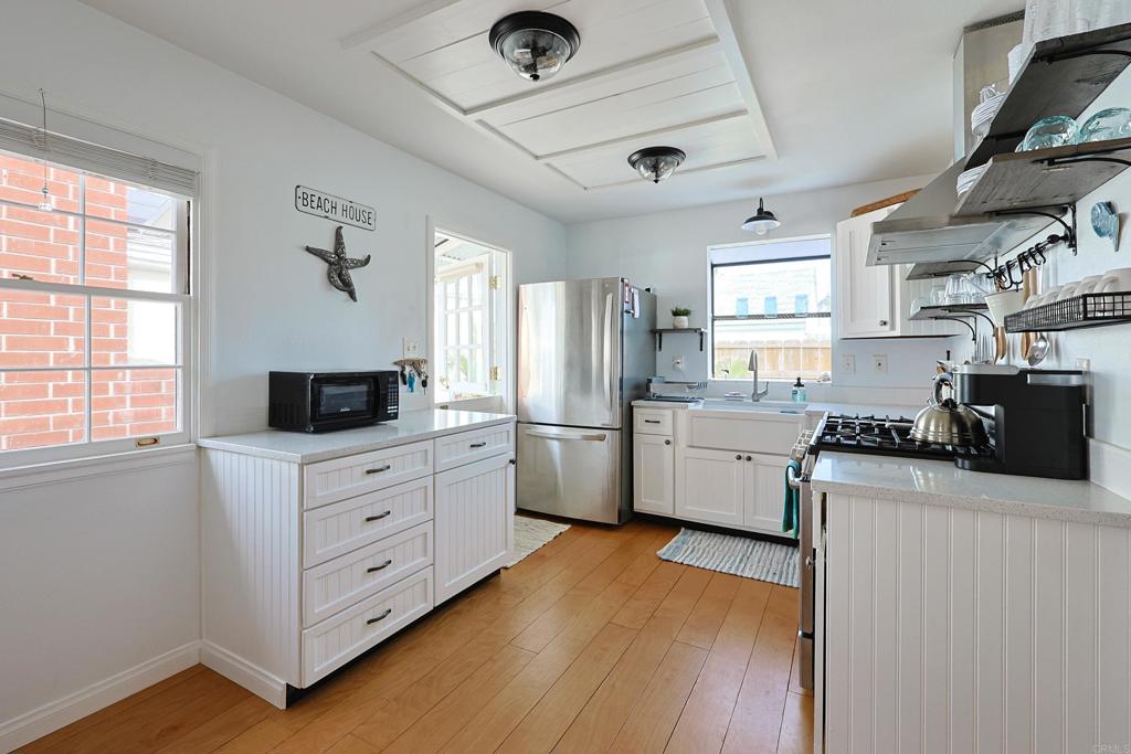 417 5th Street Coronado, CA 92118 - Photo 9 of 46 a kitchen with white cabinets and white appliances