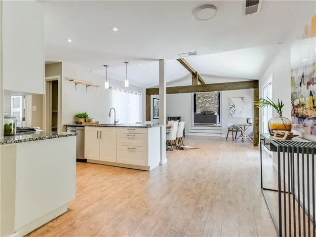 a large white kitchen with a large window and stainless steel appliances