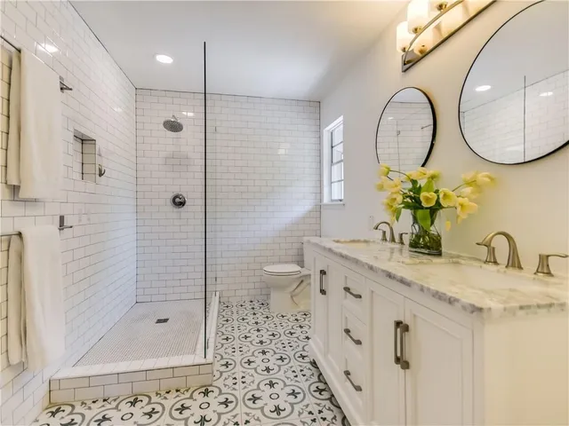 a bathroom with a granite countertop sink mirror and shower