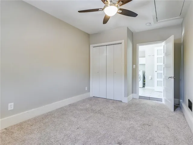 a view of an empty room with a chandelier fan
