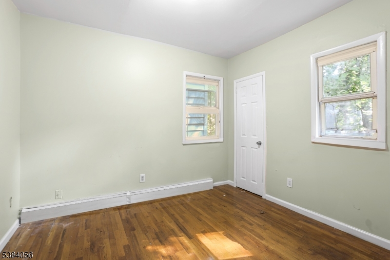 406 South 15th Street Newark, NJ 07103 - Photo 14 of 32 an empty room with wooden floor and windows