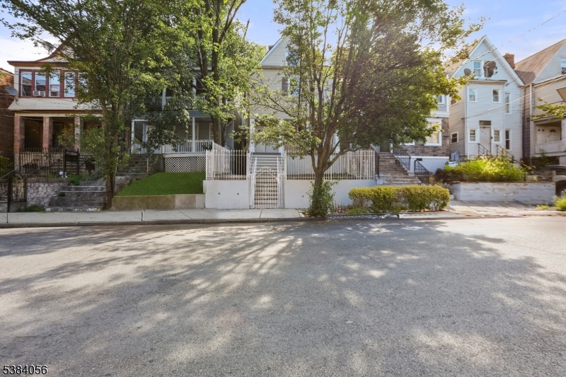 406 South 15th Street Newark, NJ 07103 - Photo 2 of 32 a view of a white house with a big yard and large trees