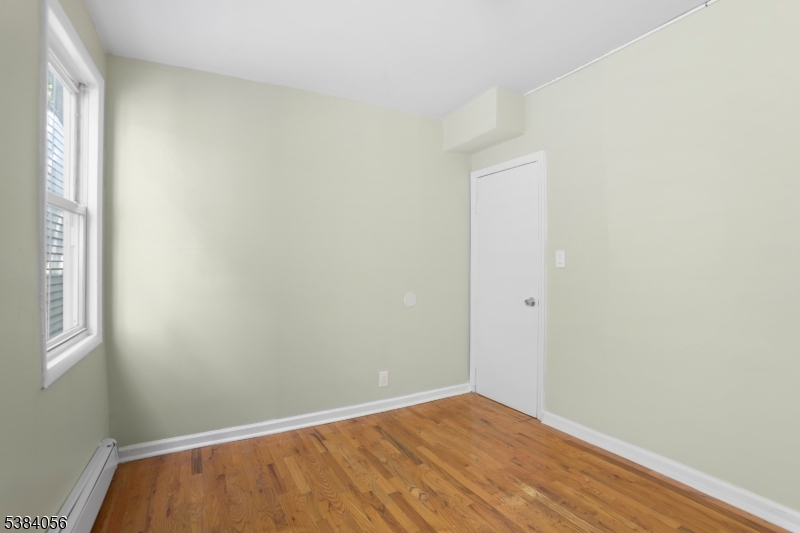 406 South 15th Street Newark, NJ 07103 - Photo 23 of 32 a view of an empty room with wooden floor and a window