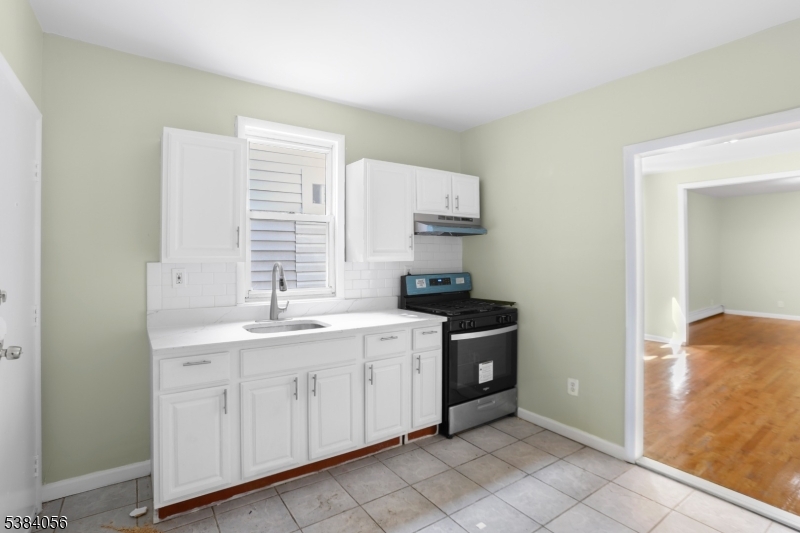 406 South 15th Street Newark, NJ 07103 - Photo 25 of 32 a kitchen with a sink stove and cabinets