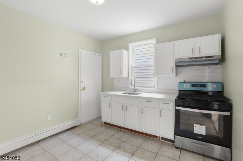 406 South 15th Street Newark, NJ 07103 - Photo 26 of 32 a kitchen with granite countertop white cabinets and white appliances