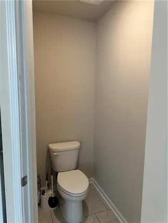a white toilet sitting next to a white wall