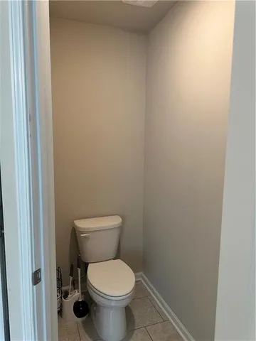 a white toilet sitting next to a white wall
