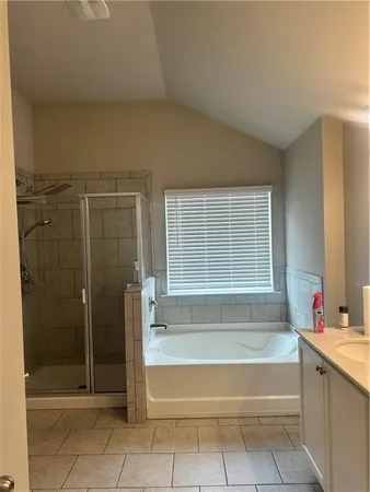 a spacious bathroom with a tub shower and sink