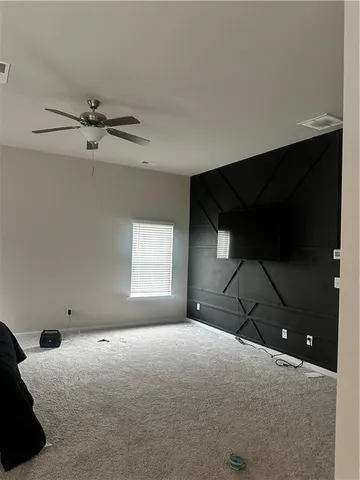 a bedroom with a bed and a chandelier fan