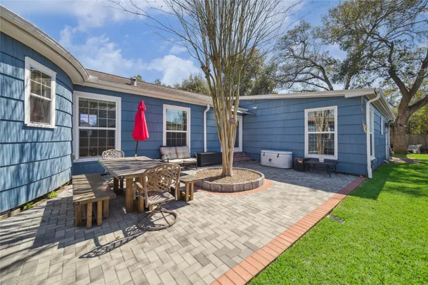 a view of house with backyard and sitting area