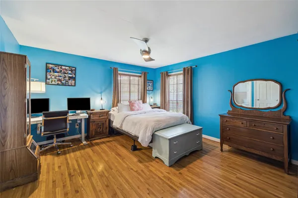 a spacious bedroom with a bed and wooden floor