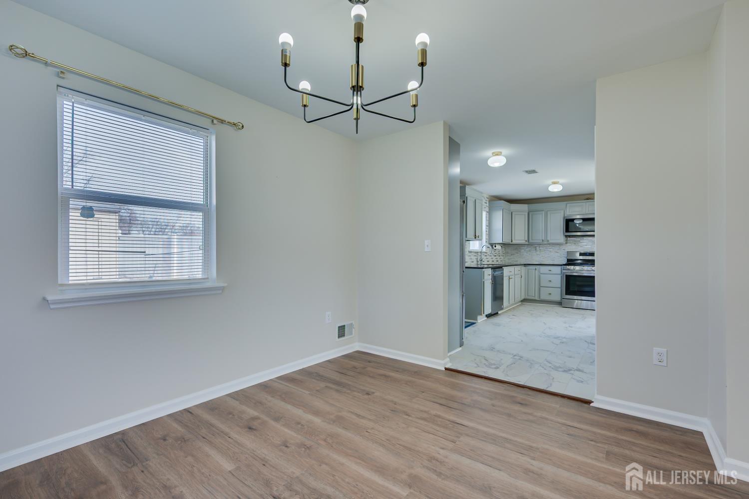 17 Idlewild Road Edison, NJ 08817 - Photo 13 of 36 a view of kitchen and empty room with wooden floor