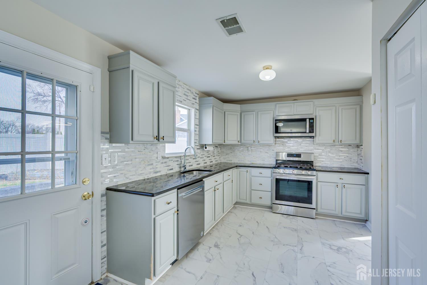 17 Idlewild Road Edison, NJ 08817 - Photo 14 of 36 a kitchen with stainless steel appliances granite countertop a stove sink and cabinets