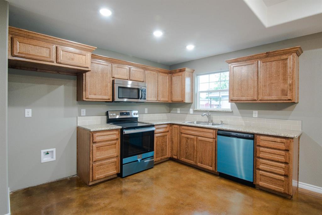 400 Allen Avenue Bonham, TX 75418 - Photo 8 of 14 a kitchen with stainless steel appliances granite countertop wooden cabinets a stove top oven a sink and dishwasher