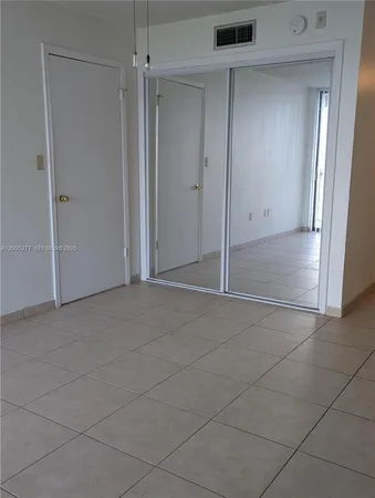 an empty room with a cabinet and a shower