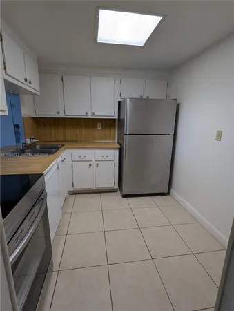 a kitchen with cabinets and steel appliances
