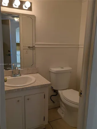 a bathroom with a toilet a sink and mirror
