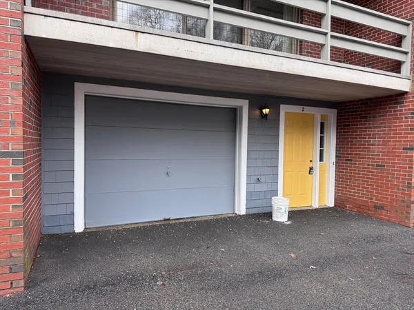 a view of empty room with wooden floor and kitchen