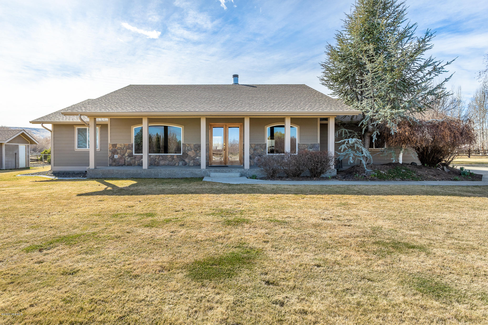 a front view of house with yard and trees around