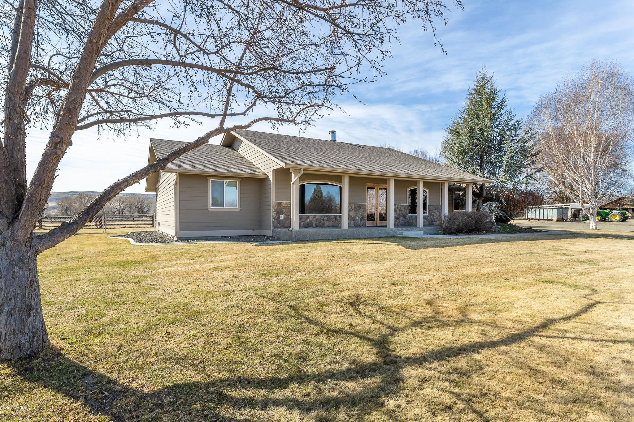12100 Rutherford Road Yakima, WA 98903 - Photo 2 of 36 a front view of a house with a yard covered with trees