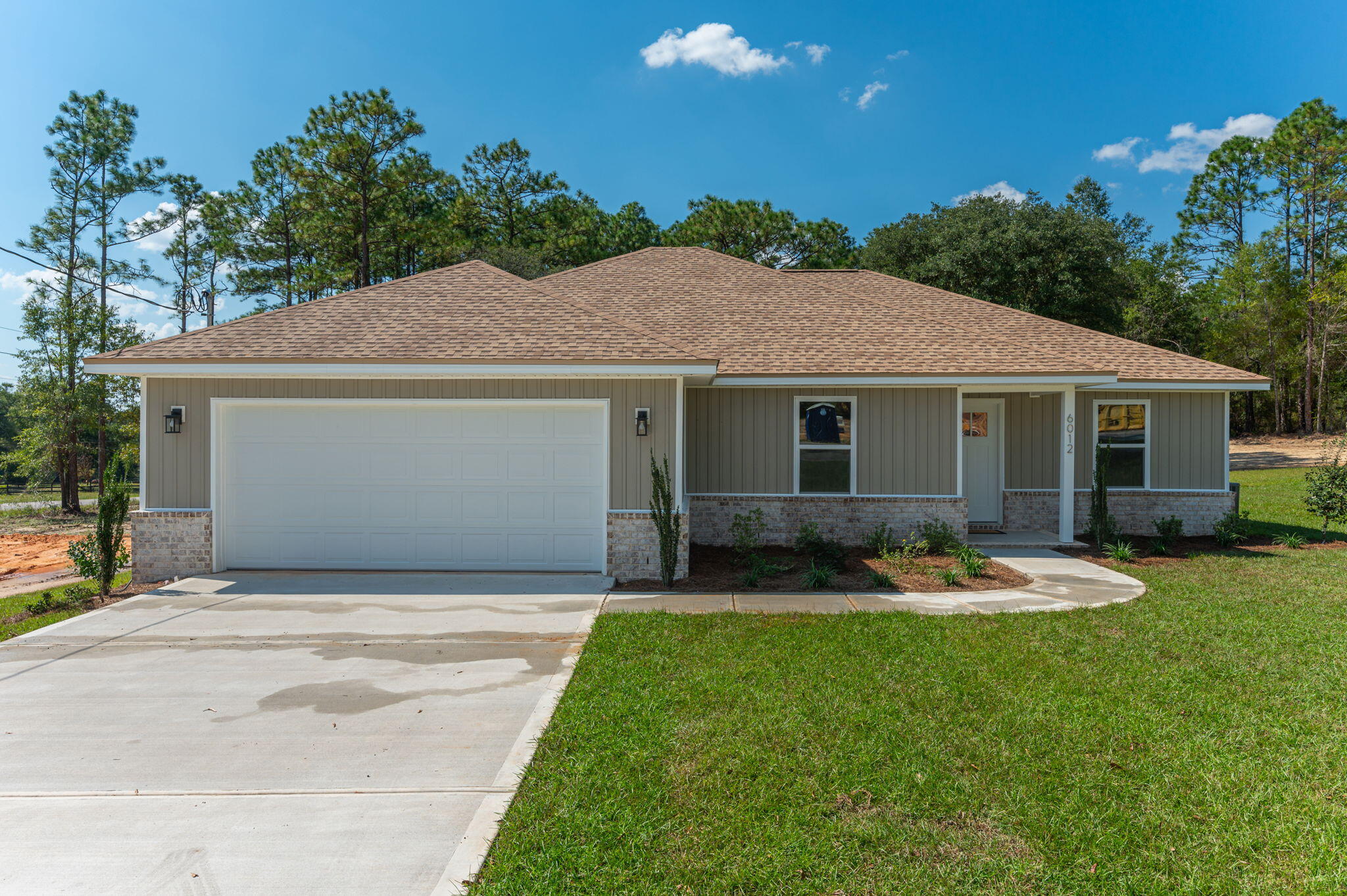 6012 Sand Hill Road Crestview, FL 32539 - Photo 1 of 45 a front view of a house with a garden and yard