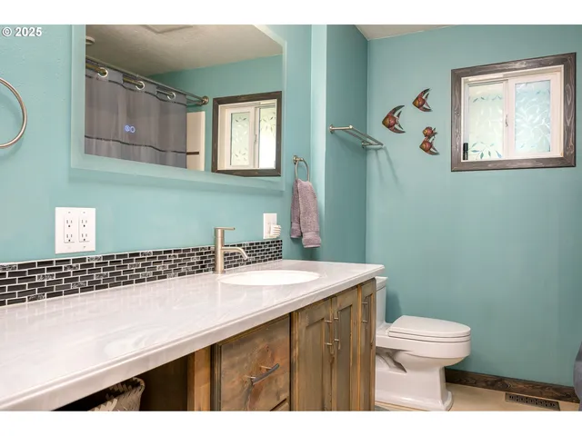 a bathroom with a sink a toilet and mirror
