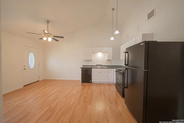 a kitchen with kitchen island white cabinets and stainless steel appliances
