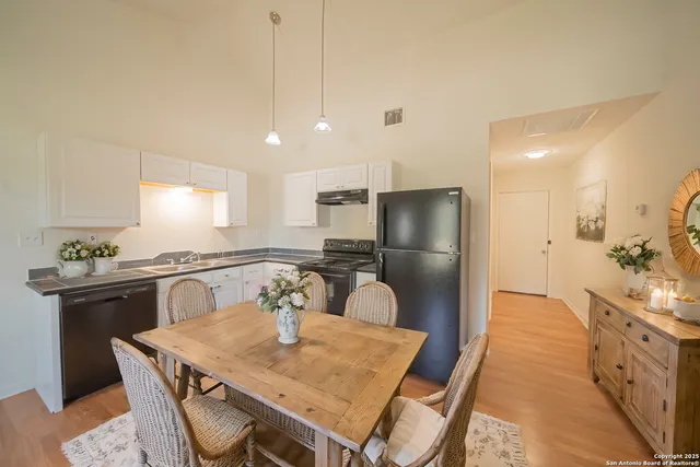 a kitchen with stainless steel appliances granite countertop a sink a stove a refrigerator with a dining table and chairs