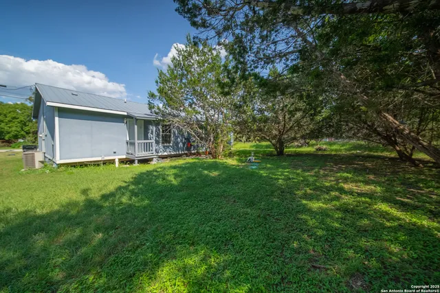 a view of backyard of house with green space