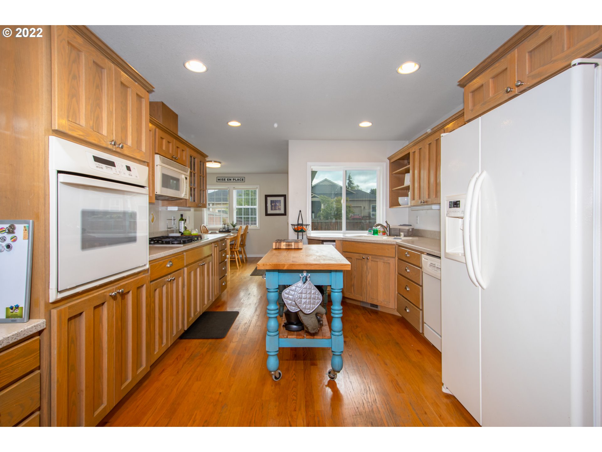 2055 South Sevier Road Ridgefield, WA 98642 - Photo 8 of 31 a kitchen with stainless steel appliances kitchen island granite countertop a refrigerator a stove a sink dishwasher with a dining table and chairs with wooden floor
