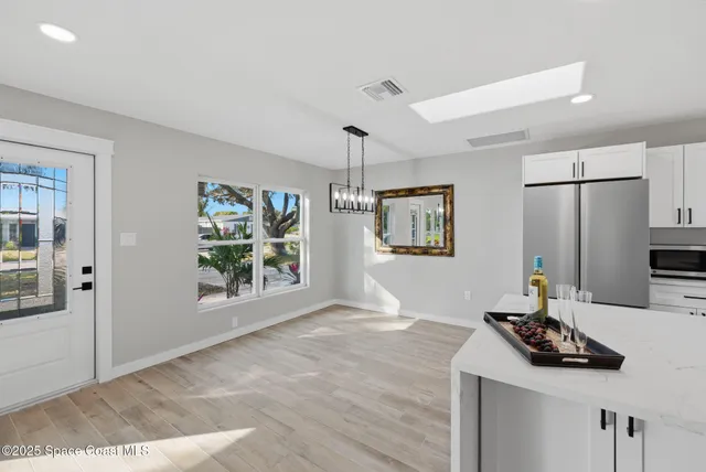 a living room with stainless steel appliances kitchen island furniture and a window