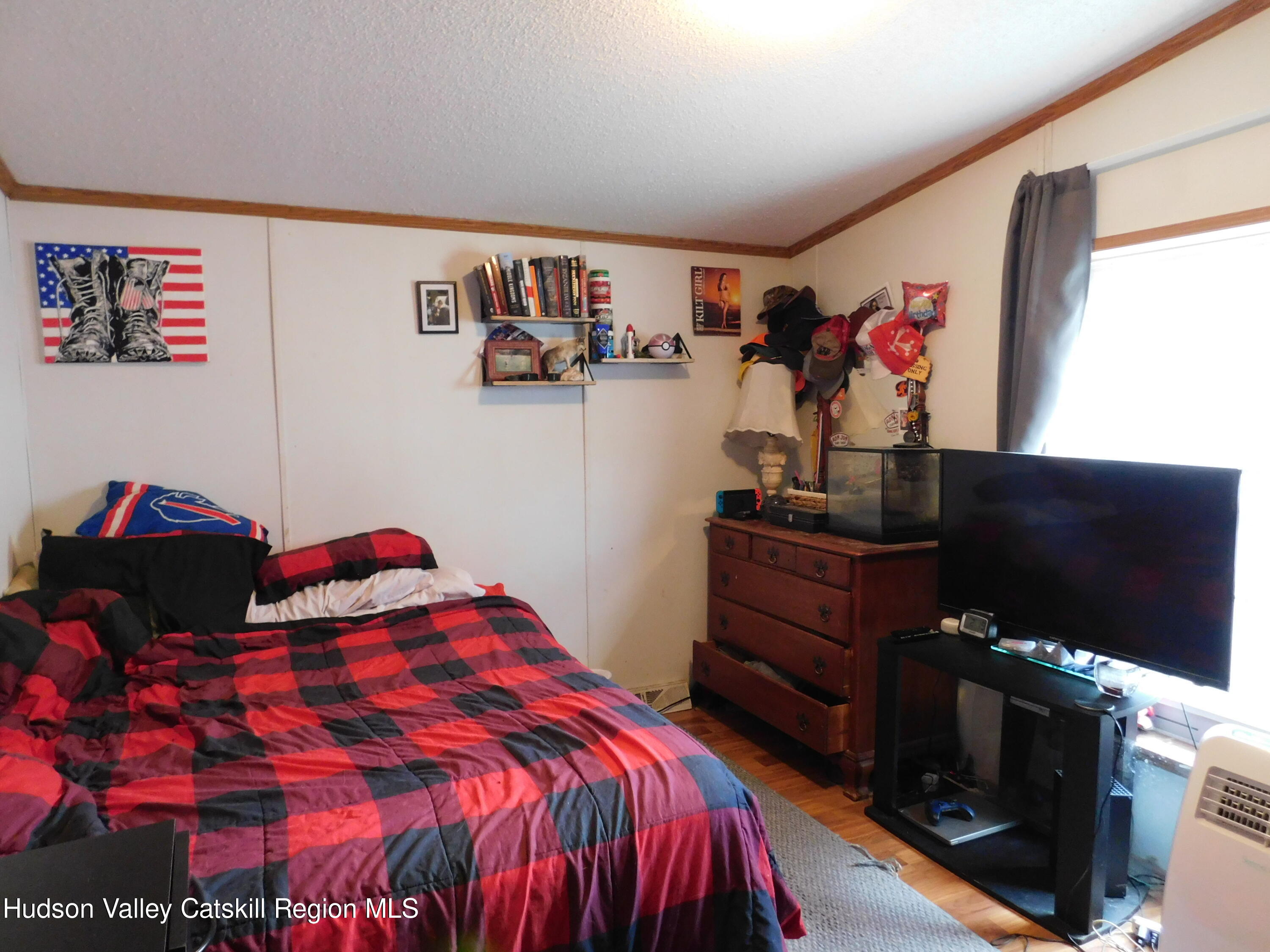 156 Lippman Road Hurleyville, NY 12747 - Photo 11 of 22 a bedroom with a bed and a flat screen tv
